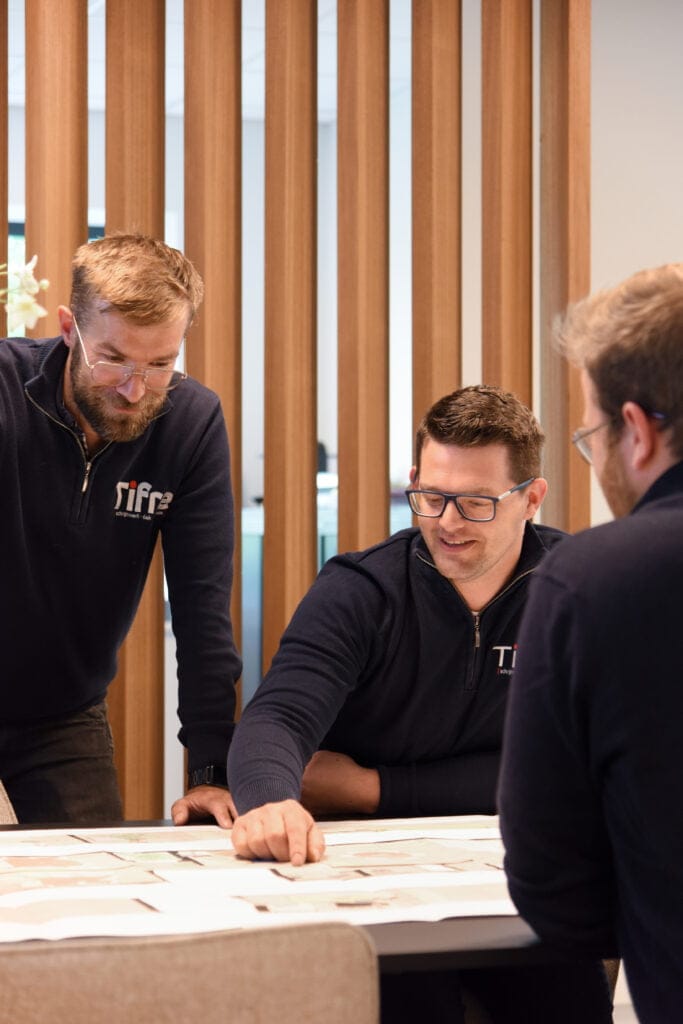 drie collega's bestuderen een bouwplan